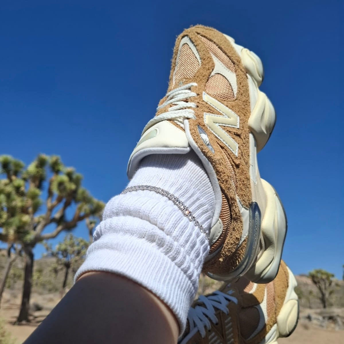 Our Jaimie diamond tennis anklet worn on top of white socks with 9060 new balance sneakers