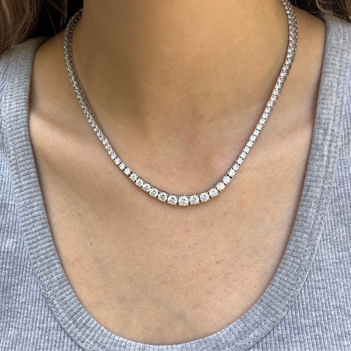 Graduated tennis necklace diamond by Leni James shown on a neck with a grey tank top