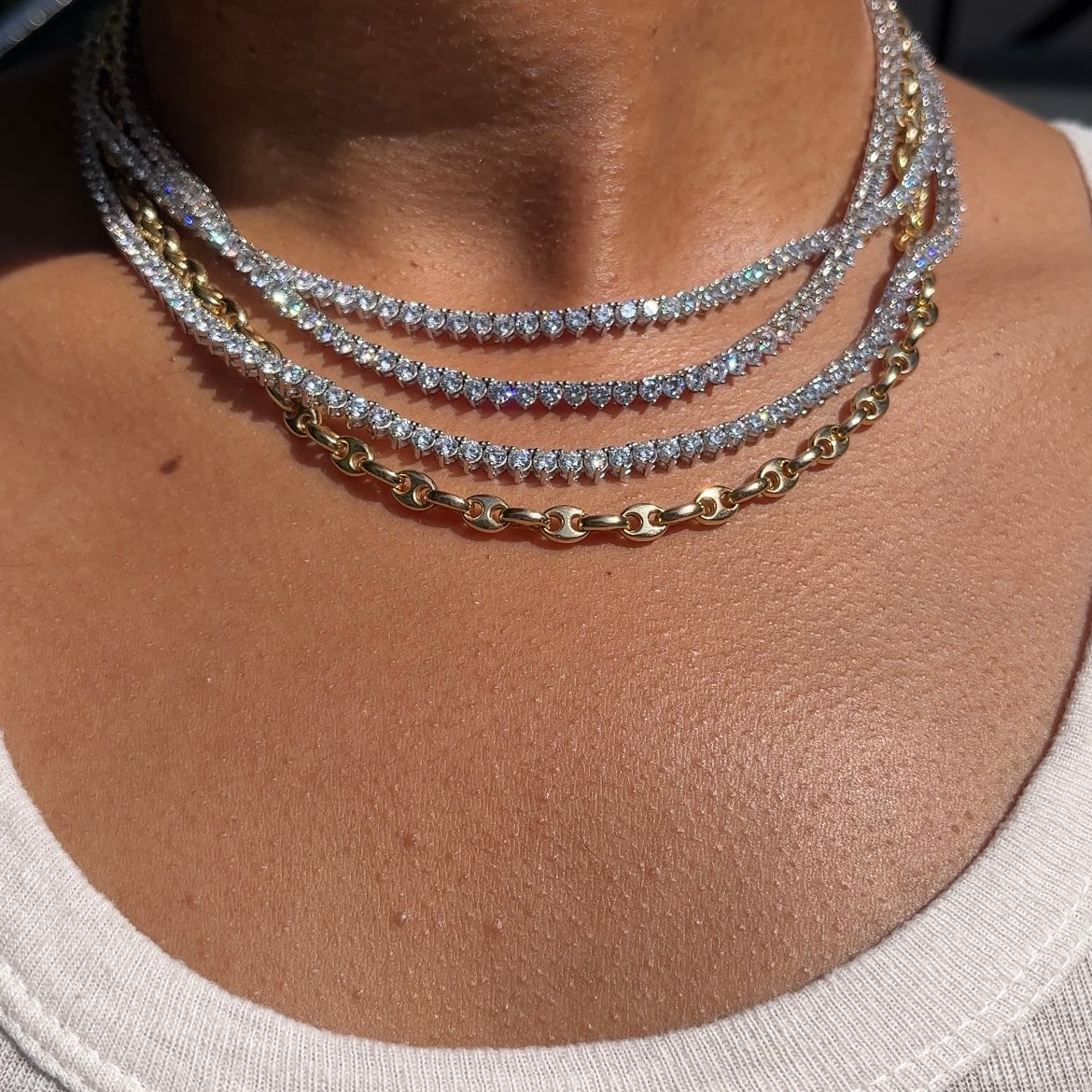Our lab grown diamond tennis necklaces when on a neck with a gold chain 