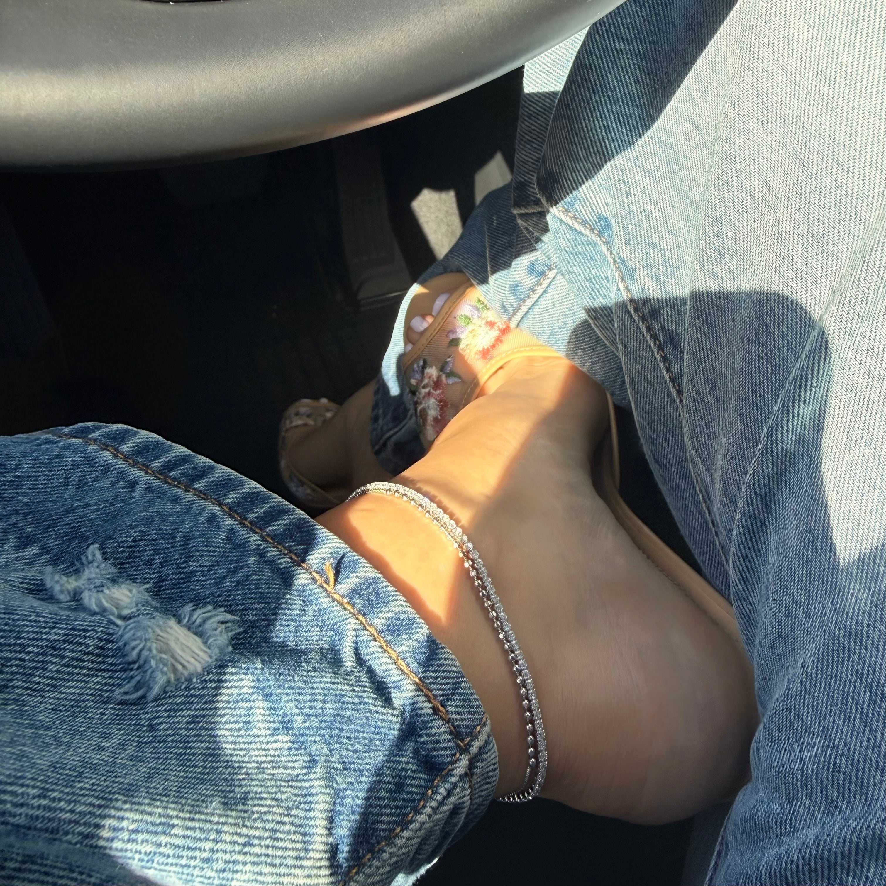 Silver beaded and tennis ankle bracelets worn with heeled mules and jeans