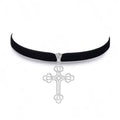 Black velvet choker with a silver cross pendant on a white background