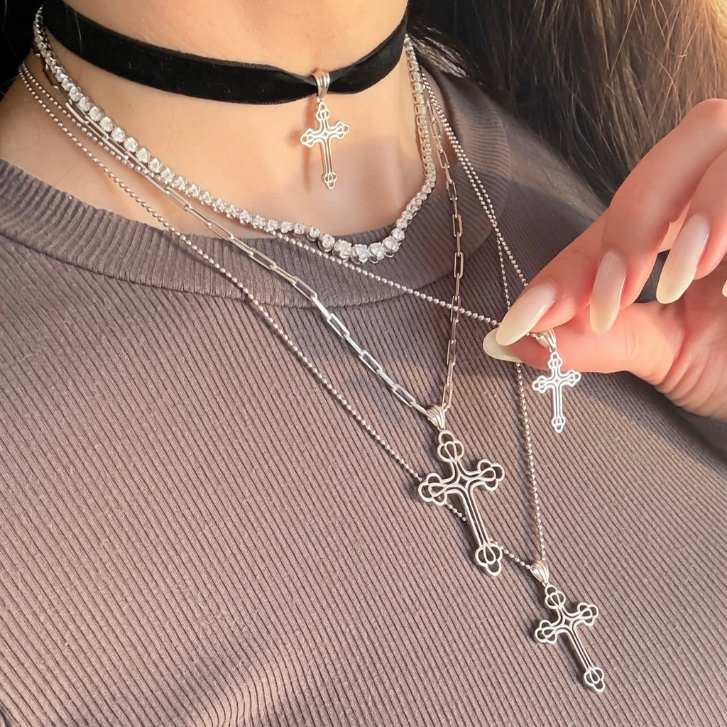 Stack of silver cross necklaces, choker, and tennis necklace 