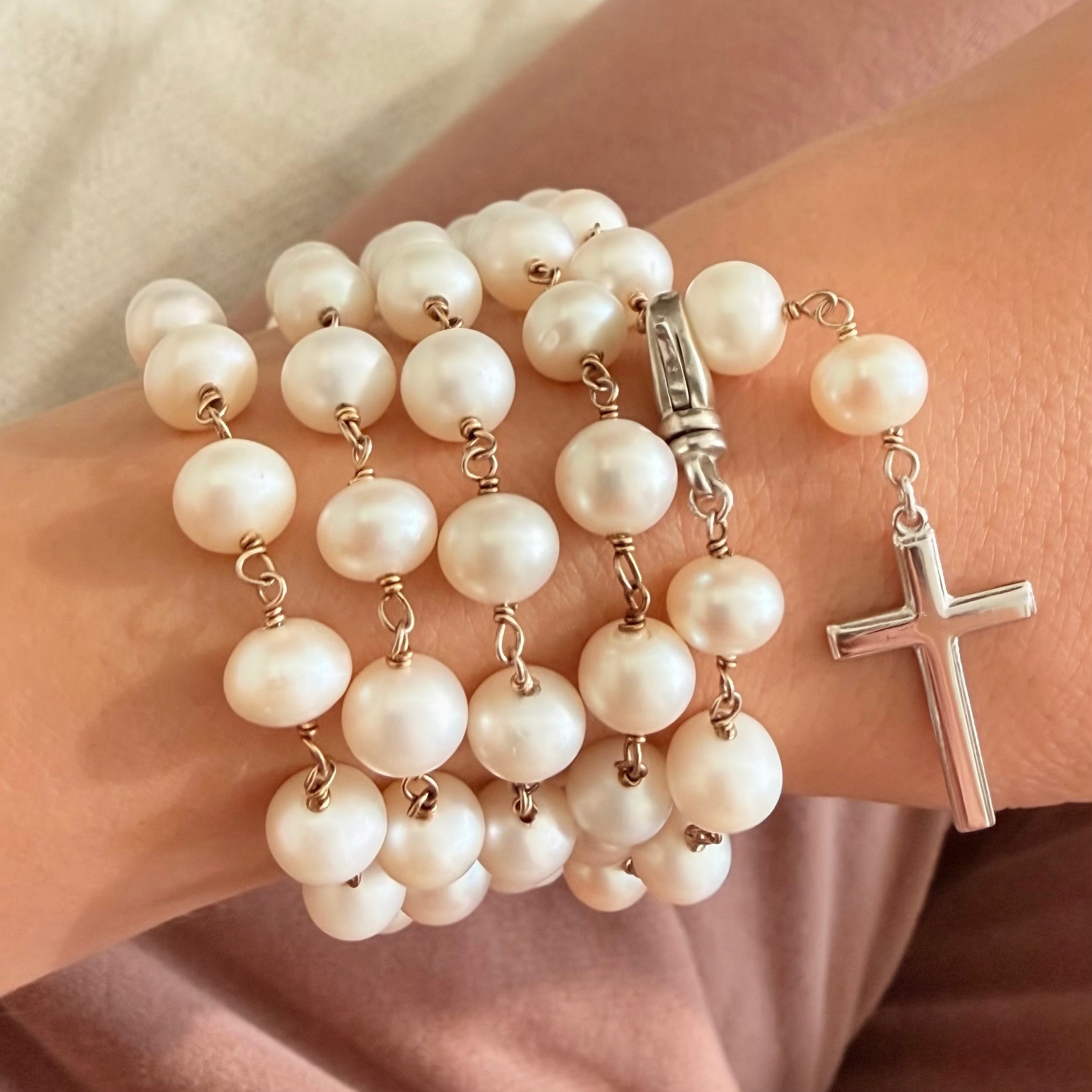 Pearl rosary wrapped around wrist