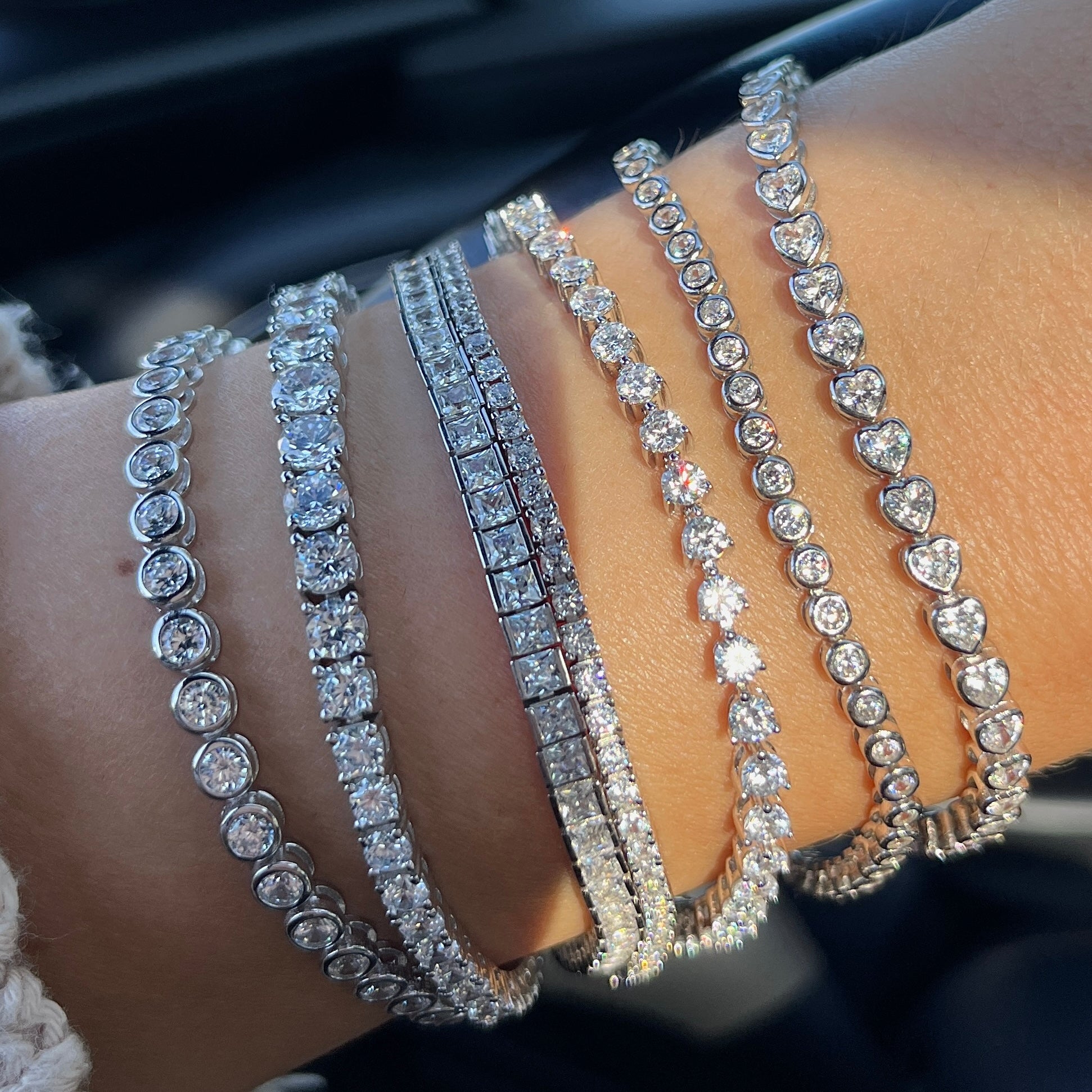 Stack of multiple faux tennis bracelets 