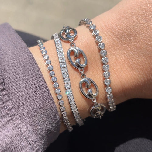 Our Fibonacci link bracelet with 3 tennis bracelets on a wrist 
