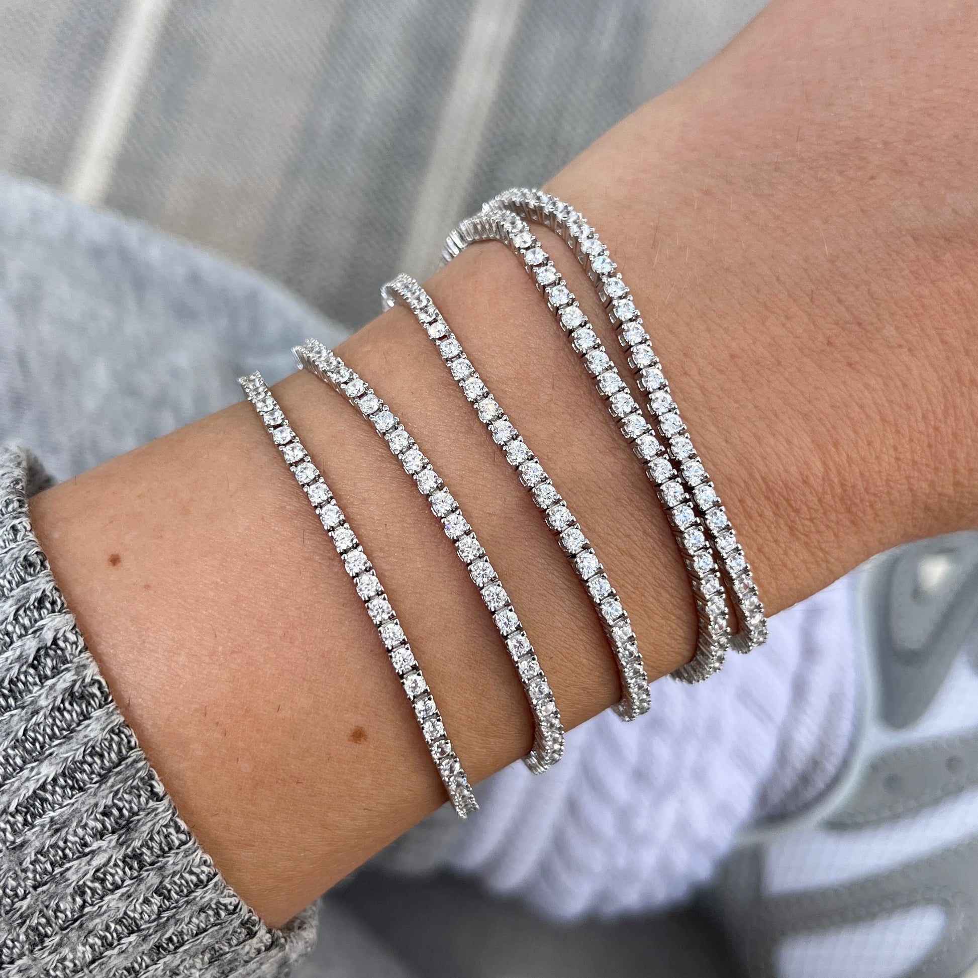 five thin tennis bracelets by Leni James shown on a wrist