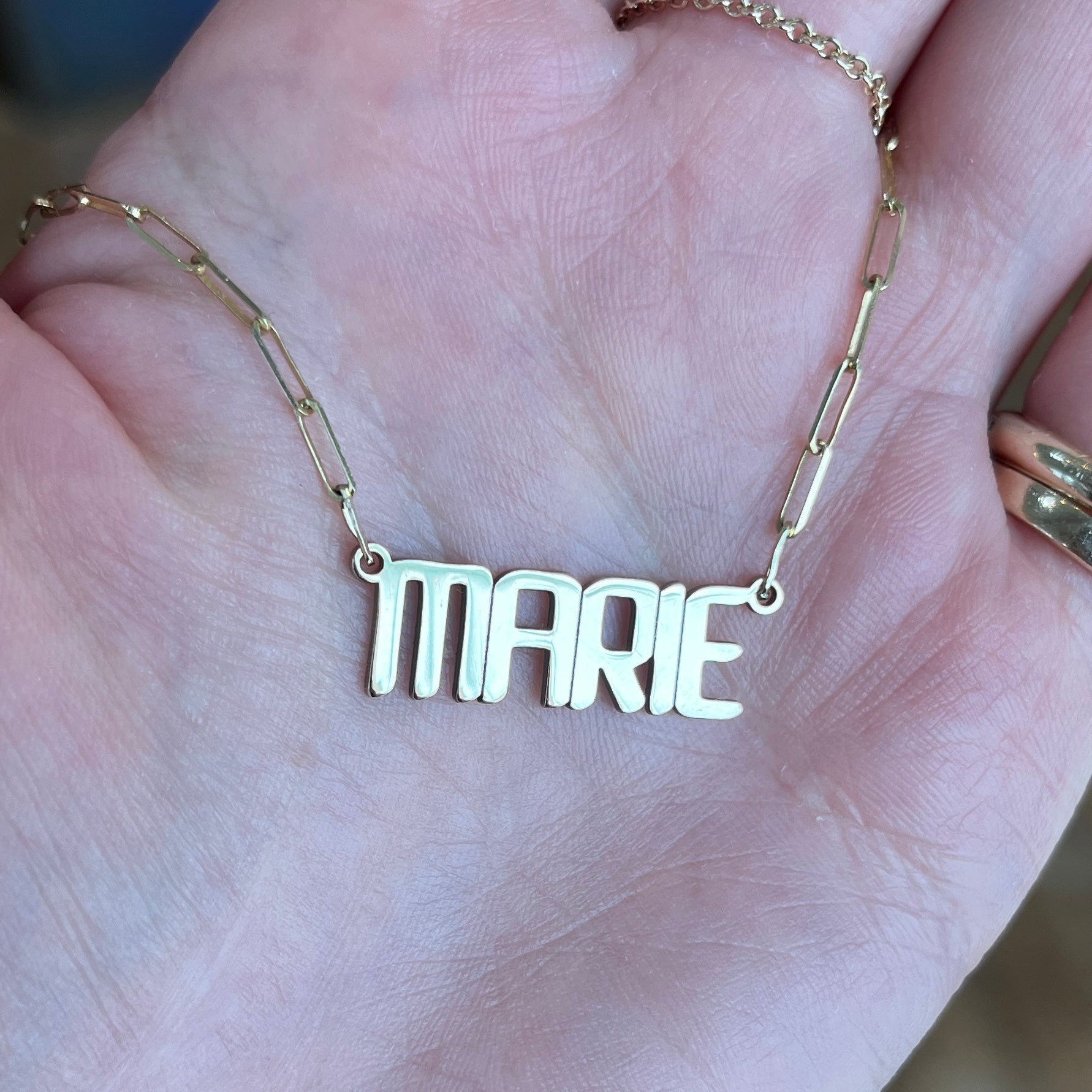 Closeup of our custom nameplate necklace with our signature font