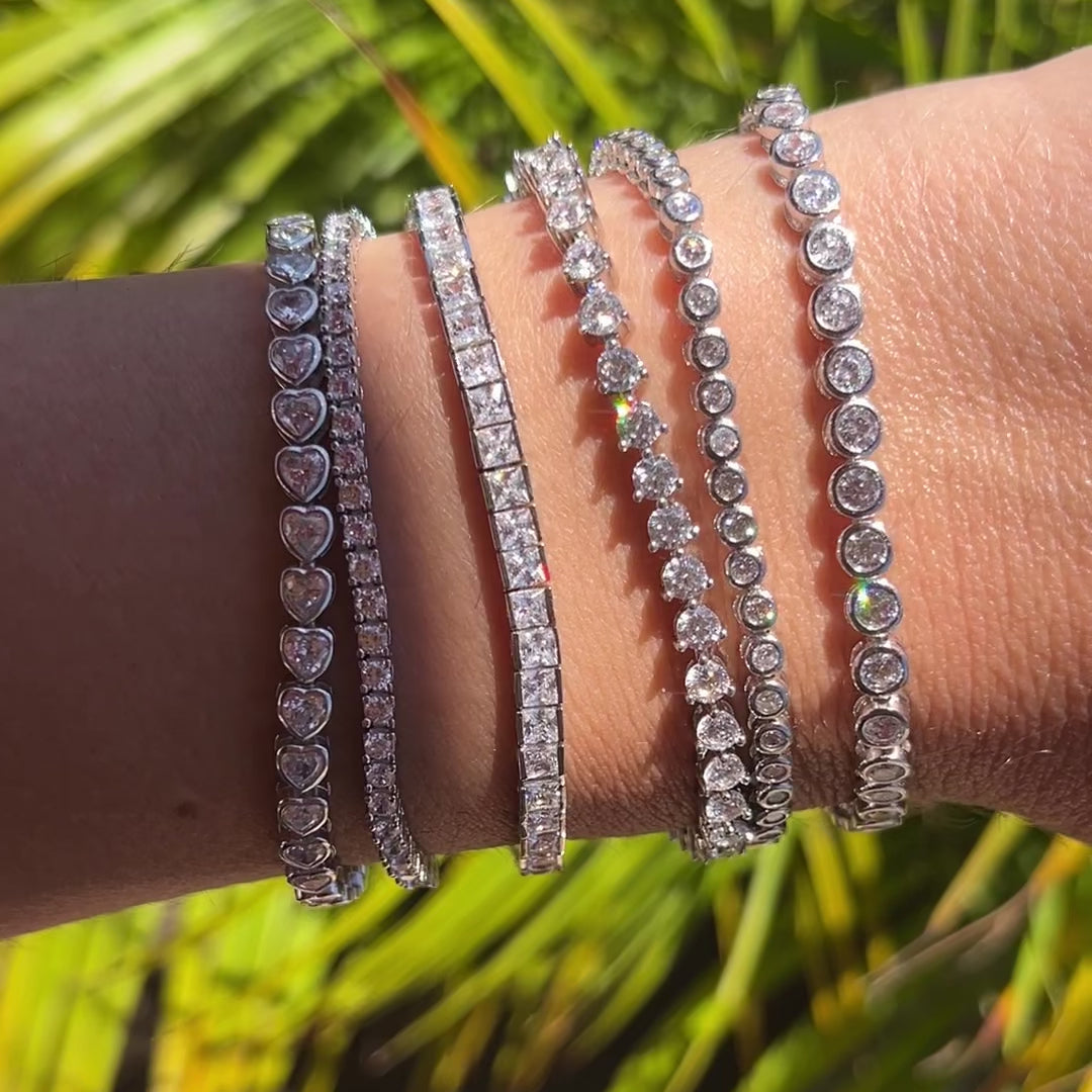 Video of our heart bezel set tennis bracelet, 3mm tennis bracelet, and thin tennis bracelet, on a wrist in the sun